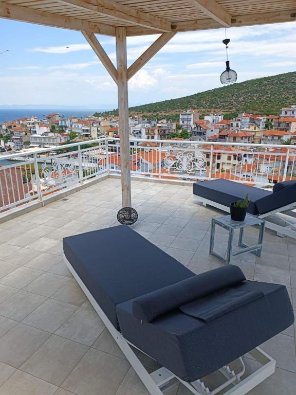 a patio with two chairs and a table on a balcony at Villa Skala Marion (Michalis) in Skala Marion