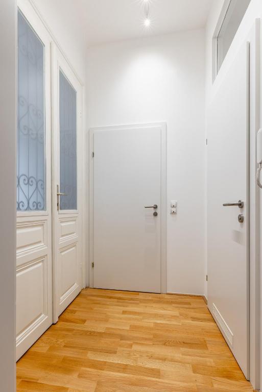 an empty room with white walls and wooden floors at Trendy apt with - smart TV, coffee machine in Meidling in Vienna