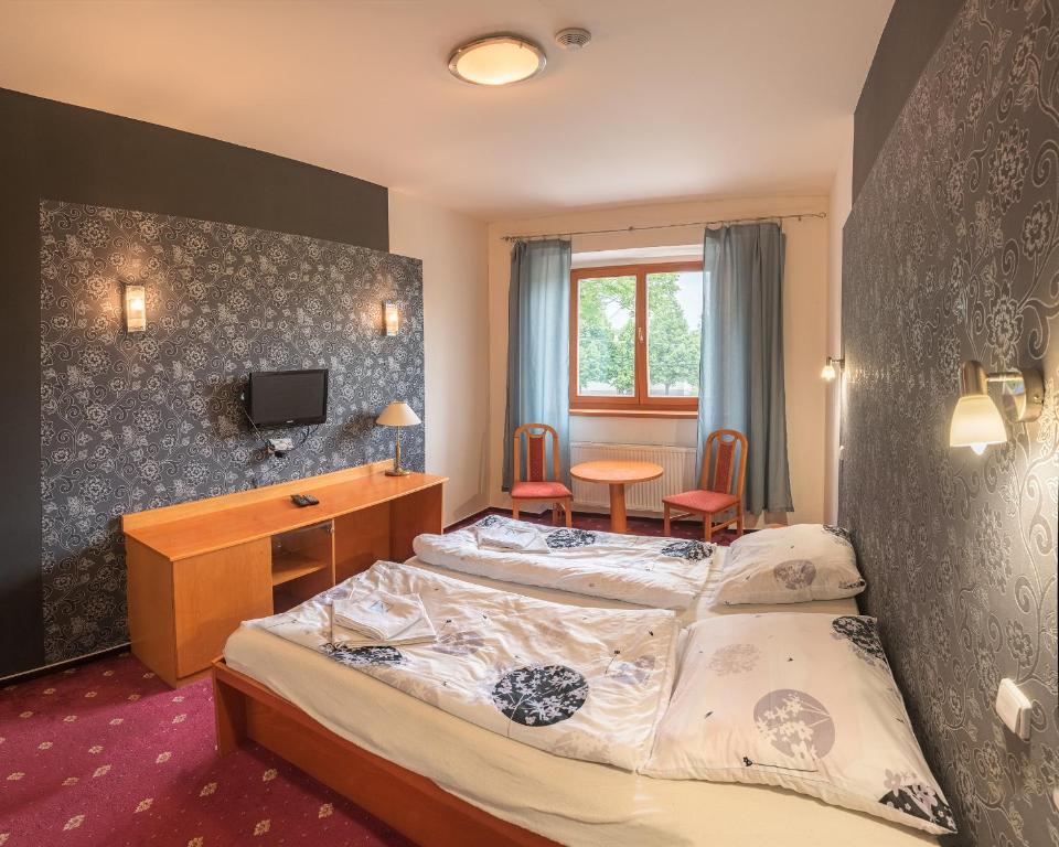 een hotelkamer met 2 bedden en een bureau bij Dobrá škola u Jeníčka in Vojkovice