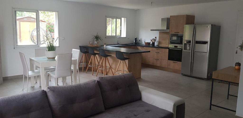 Il comprend une cuisine équipée d'un canapé, d'une table et d'un réfrigérateur. dans l'établissement Maison sur les hauteurs d'Ajaccio, à Valle-di-Mezzana