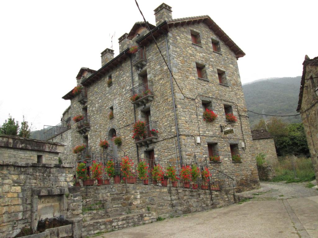 un edificio con flores a un lado. en La Abadía de Fragen-Ordesa, en Torla