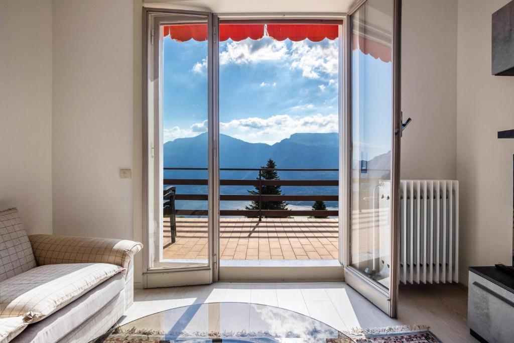uma sala de estar com um sofá e uma grande porta de vidro em Wohnung mit grandiosem Ausblick em Tremosine Sul Garda