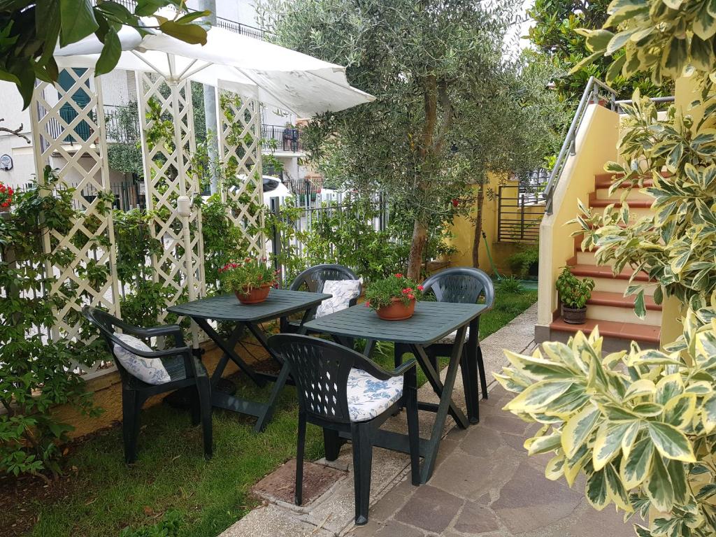 a patio with two tables and chairs and an umbrella at Casa LorEn in Pesaro