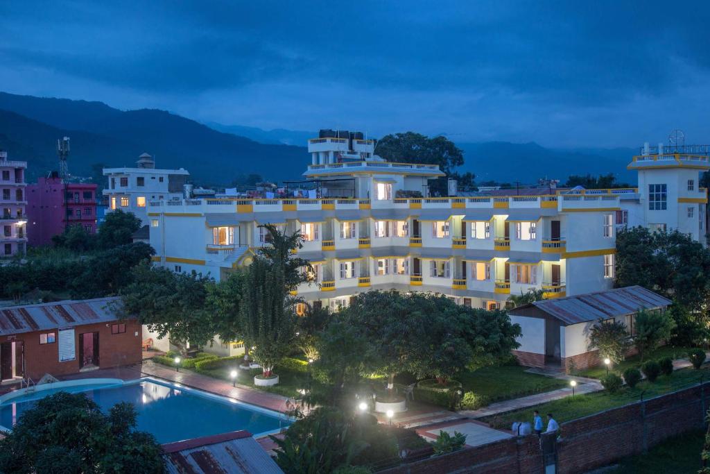 um hotel com piscina em frente a um edifício em Siddhartha Sunny Resort, Surkhet 
