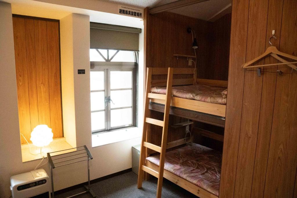 Ένα ή περισσότερα κρεβάτια σε δωμάτιο στο TSUDOI guest house