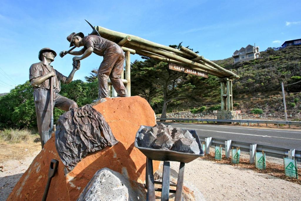 a statue of two men standing next to a street at Beachside At Breakers in Lorne