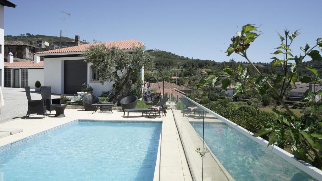 uma piscina em frente a uma casa em Casas do Aidro em Freches