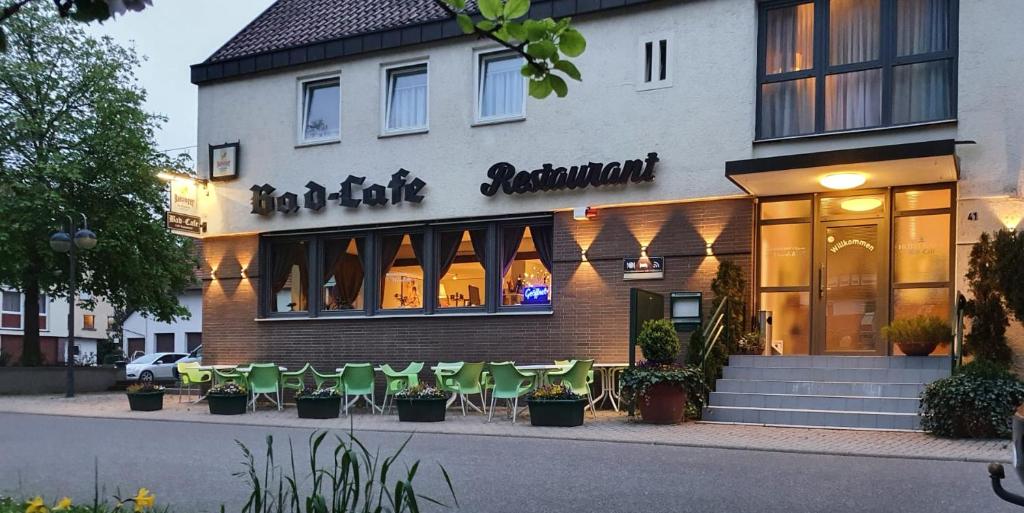 a restaurant with green chairs in front of a building at Hotel garni Bad Café Bad Niedernau in Bad Niedernau