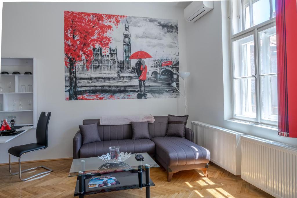 a living room with a couch and a painting on the wall at Biztos Kuckó in Szeged