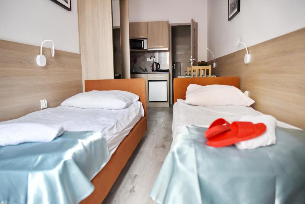 two beds with red pillows on them in a room at Pokoje Gościnne Przemyk in Rewa