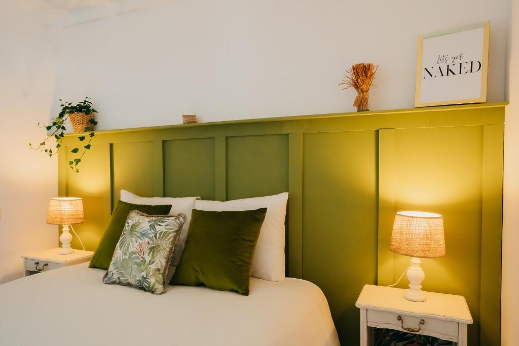 una camera da letto con un letto con testiera verde di Villa Rafa a Costa Nova