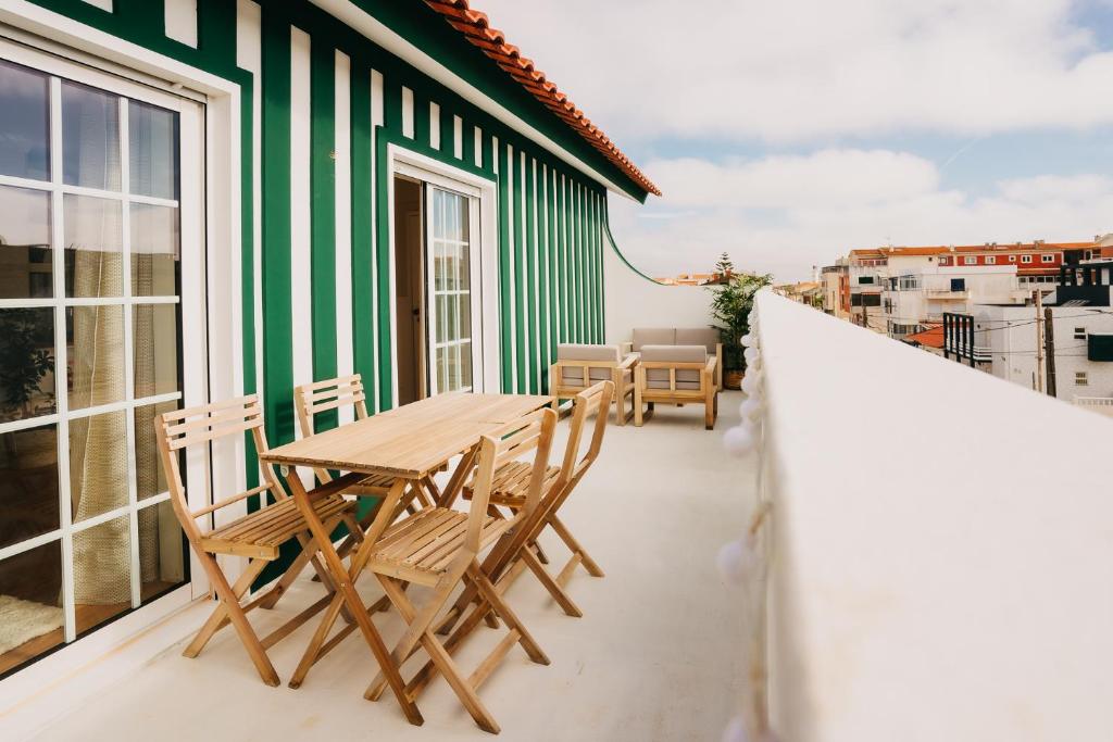 d'un balcon avec une table et des chaises en bois. dans l'établissement Villa Rafa, à Costa Nova