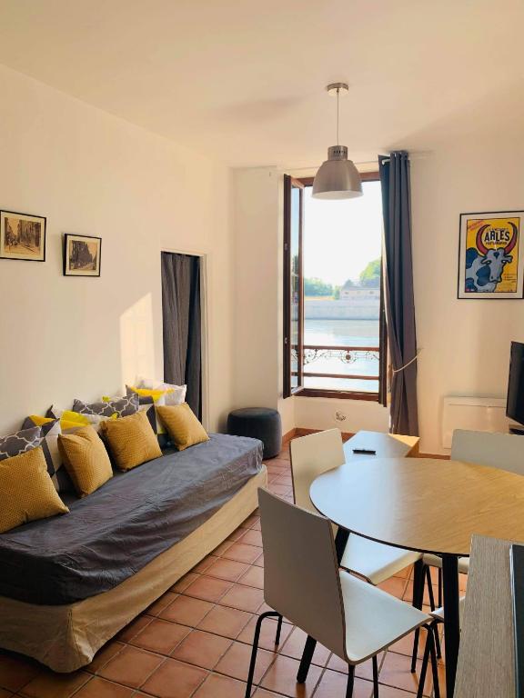 a living room with a bed and a table at Sur les quais... in Arles