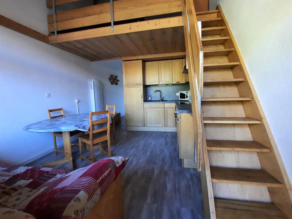 een kamer met een trap, een tafel en een keuken bij Appartement Les Menuires, 2 pièces, 6 personnes - FR-1-452-205 in Les Menuires