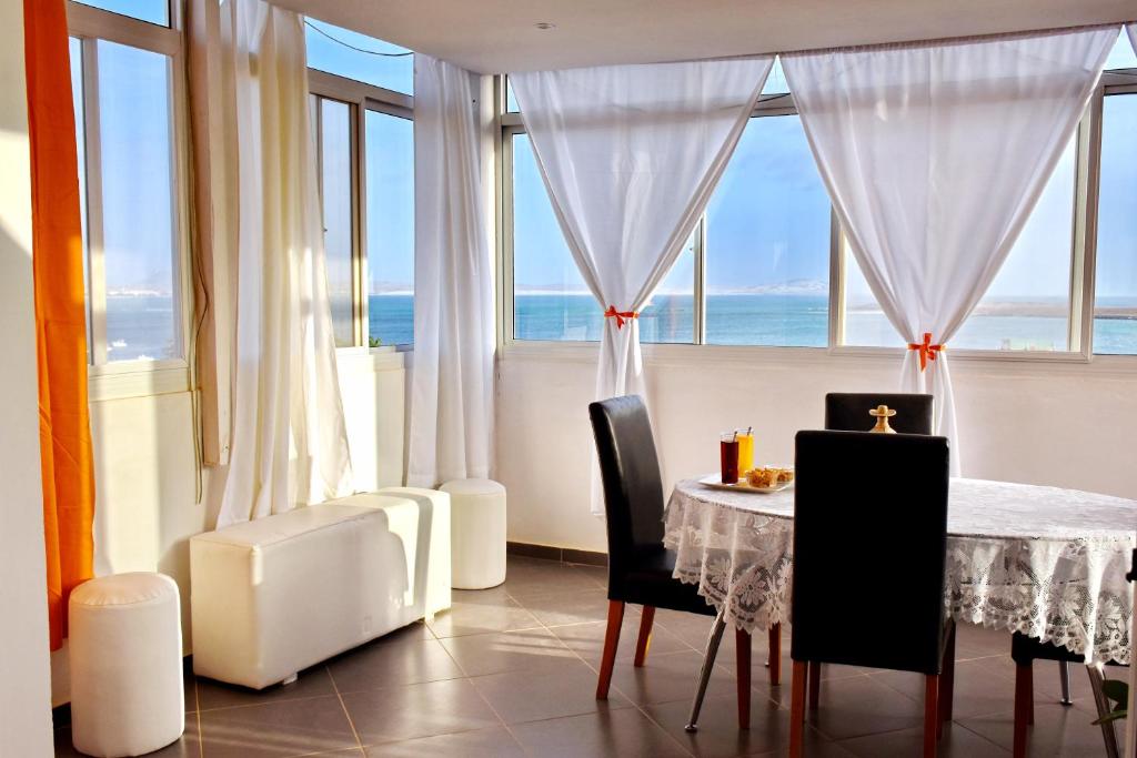 a dining room with a table and a view of the ocean at Apartamento moderno com vista para o mar in Sal Rei