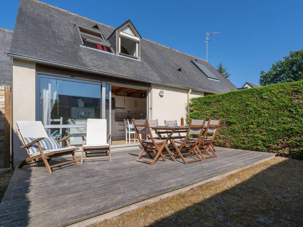 une terrasse en bois avec des chaises et une table dans l'établissement Maison de charme à Carnac, 2 pièces, 45m², WiFi, proche plage et commerces - FR-1-477-106, à Carnac