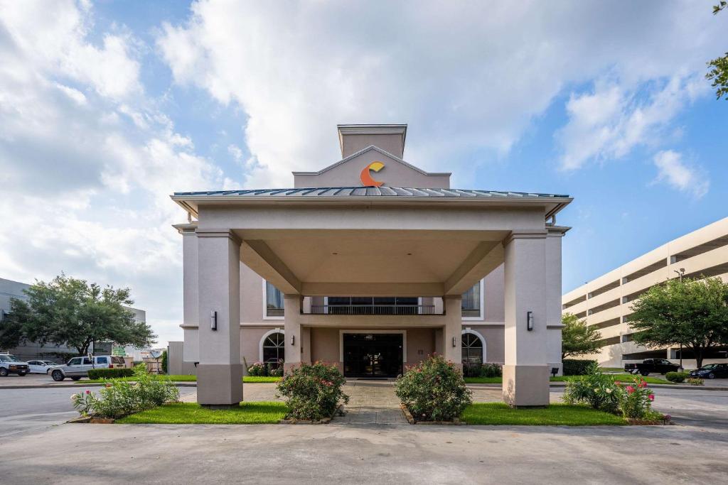 um edifício com uma torre de relógio em cima em Comfort Suites Houston West at Clay Road em Houston