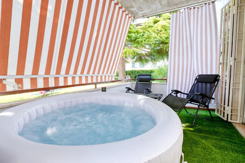 a hot tub on a patio with two chairs at Wolf House - Peschiera Holiday - Jacuzzi Privata in Peschiera del Garda