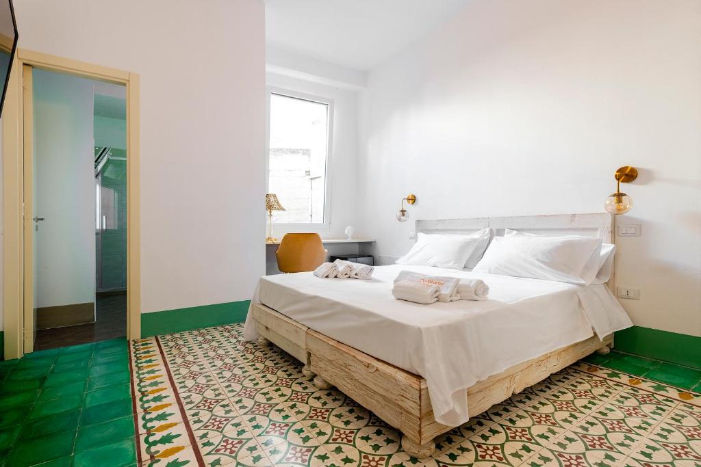 a bedroom with a large bed with white sheets at Damasa Rooms in Lecce