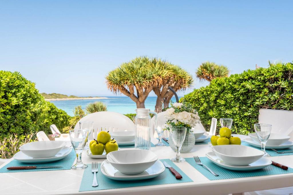 a table with a blue and white table set with a view of the ocean at Bellamirada - Punta Prima Playa in Punta Prima