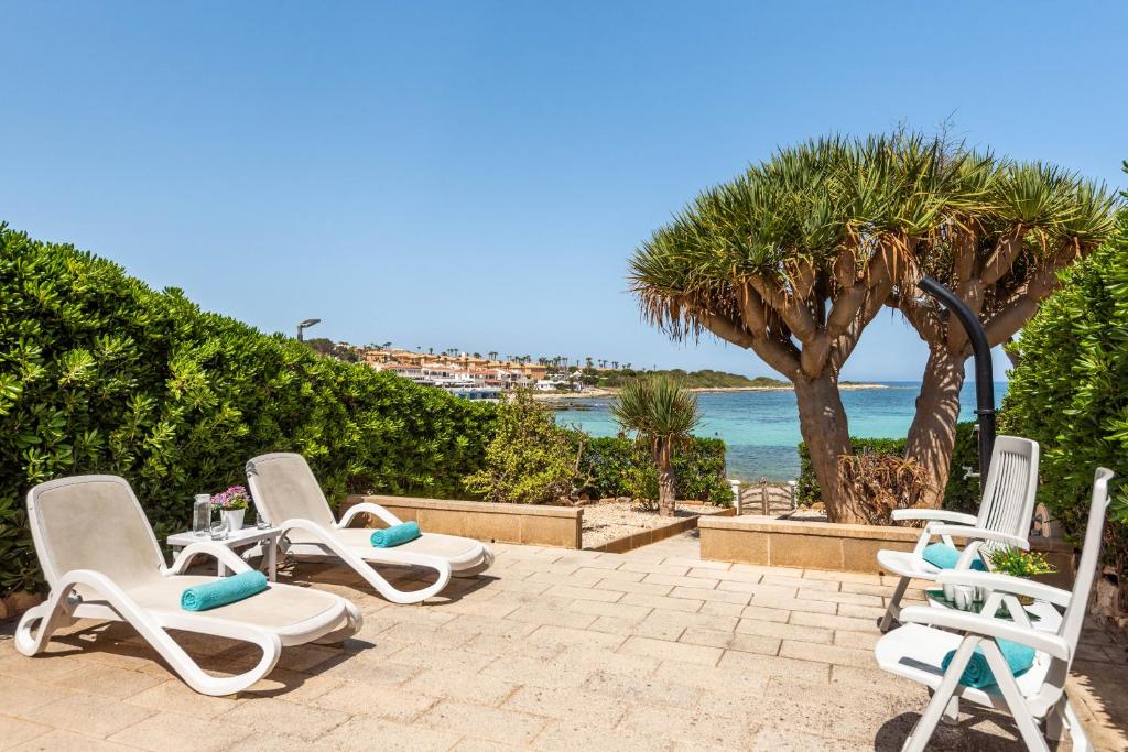 Un grupo de tumbonas junto al océano. en Bellamirada - Punta Prima Playa, en Punta Prima