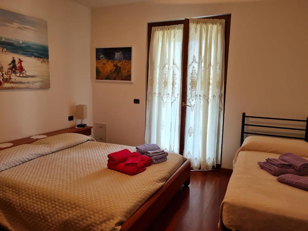 1 dormitorio con 2 camas individuales y ventana en Casa Andrè en Pescantina