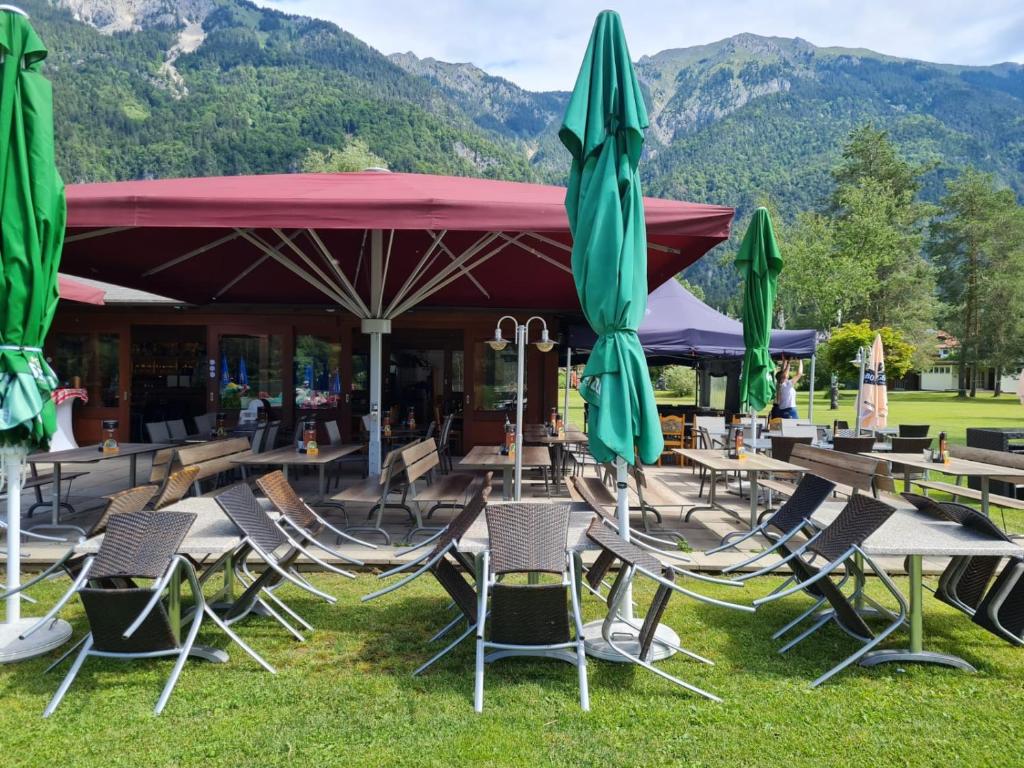 a group of chairs and tables with umbrellas at Bungalow Fritz in Presseggen