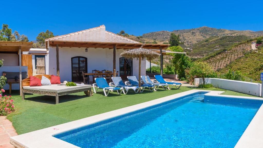 a backyard with a pool and chairs and a house at Casa El Mirador de Isabel Vélez-Málaga by Ruralidays in Vélez-Málaga