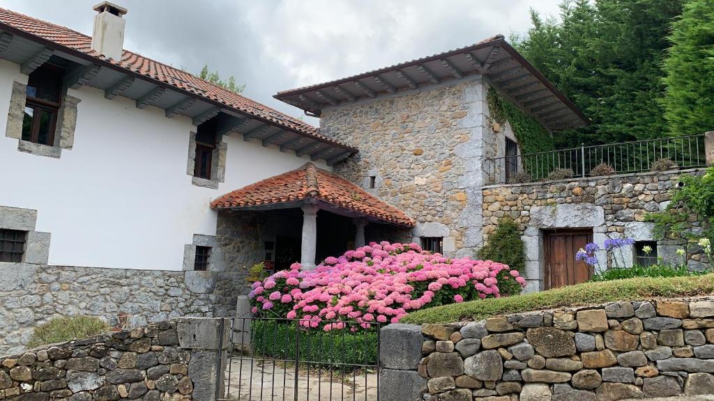 a house with pink flowers in front of it at El Jardin de las Magnolias Hotel in Quintana de Soba