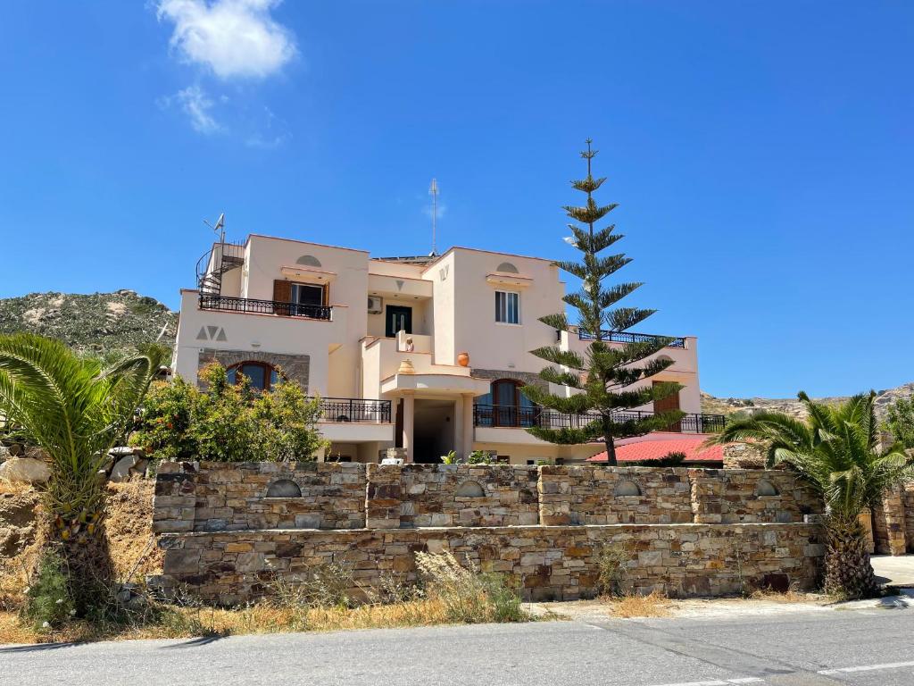 a large house behind a stone retaining wall at Tranquil Apartments in Naxos Chora