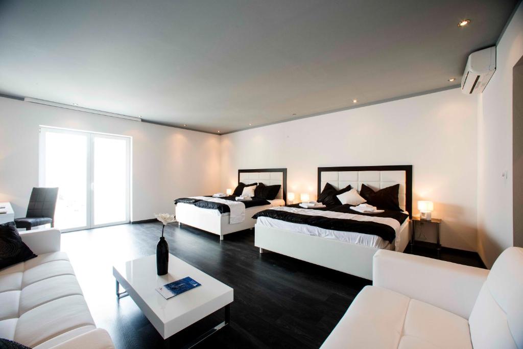 a bedroom with two beds and a living room with a couch at The Suites Small Luxury Living 24/7 contactless check in in Vodice