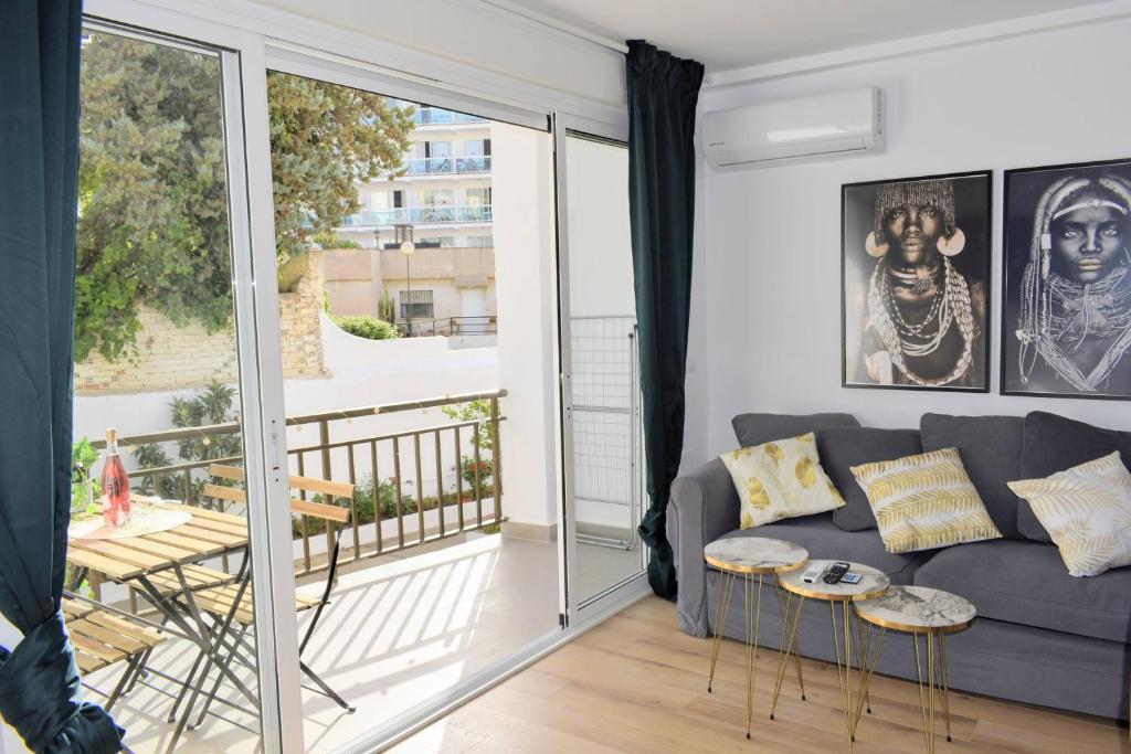 sala de estar con sofá y balcón en Mediterraneo Carihuela - Torremolinos en Torremolinos