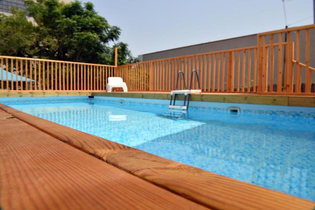 a large swimming pool with a chair in it at Domos Tiberias דומוס טבריה in Tiberias