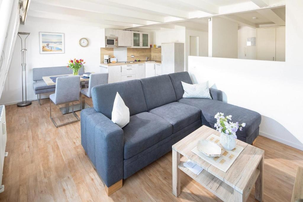 sala de estar con sofá azul y mesa en Haus 3 Jahreszeiten Wg 16 en Norderney