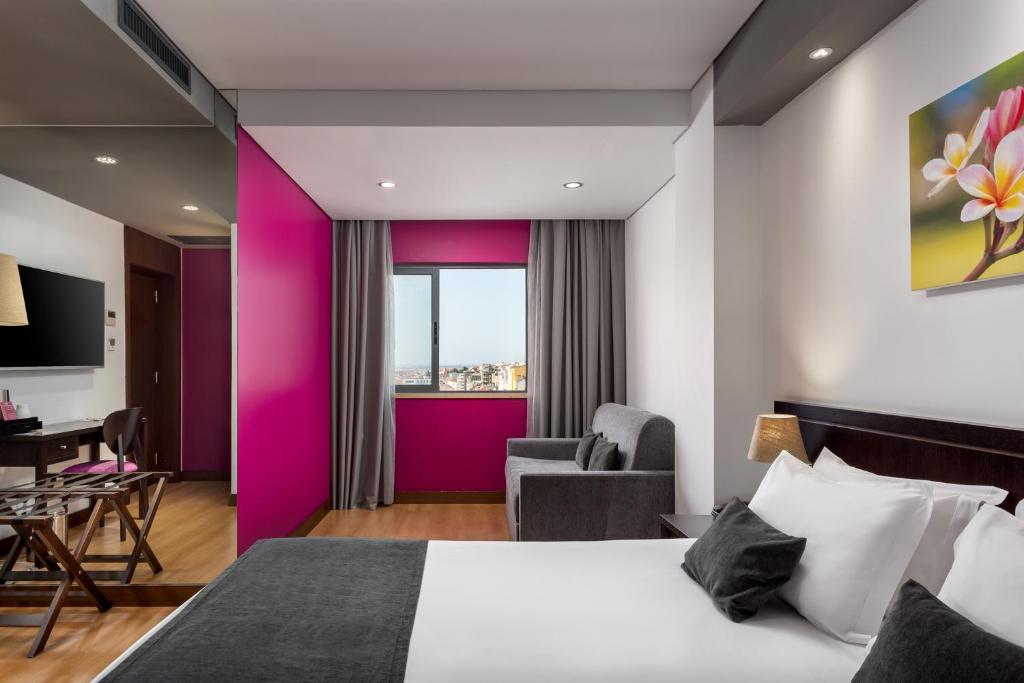 A colorful room with a double bed, armchair, desk area, and city-facing window.