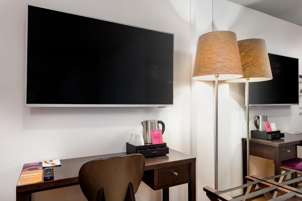 A compact in-room work desk beneath a wall-mounted television.