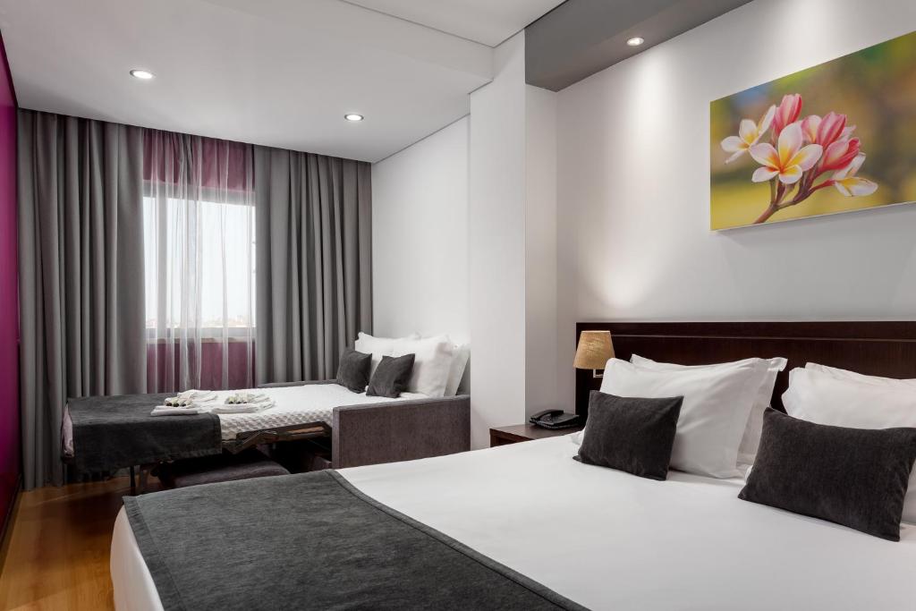 A bright double room with two beds, a window, and a small seating area.