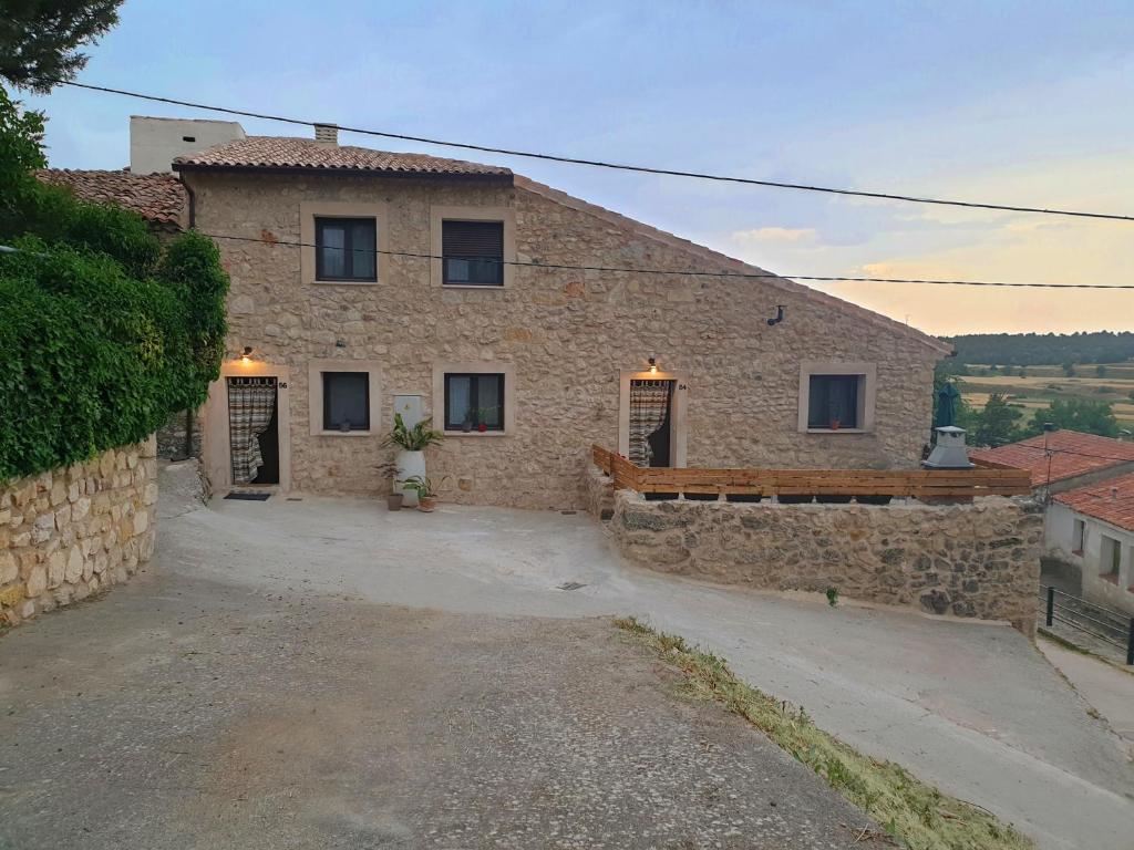 a stone house with a stone wall at CASAGUAPA Alto Tajo in Armallones