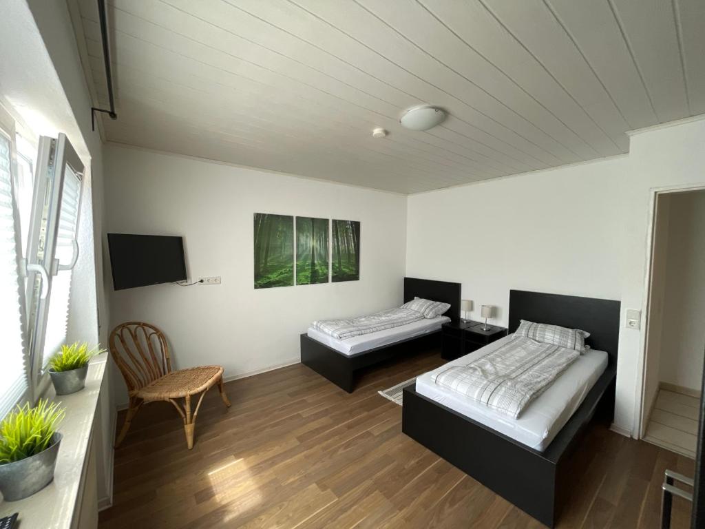 GladenbachにあるFerienwohnung Hausのベッド2台と椅子が備わる客室です。