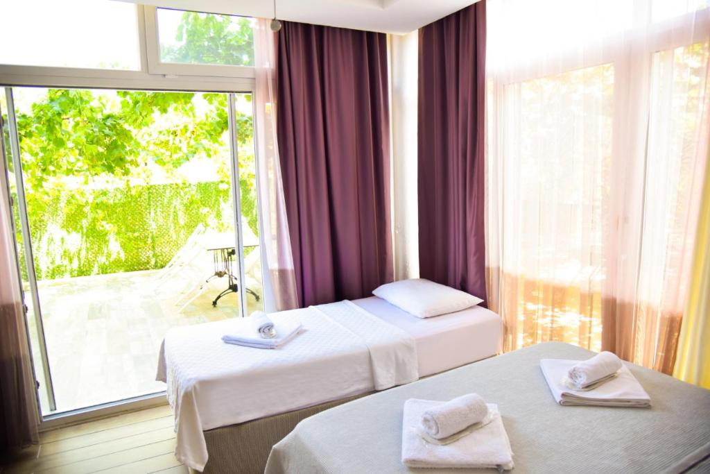 a hotel room with two beds and a large window at Balim Sultany in Çeşme