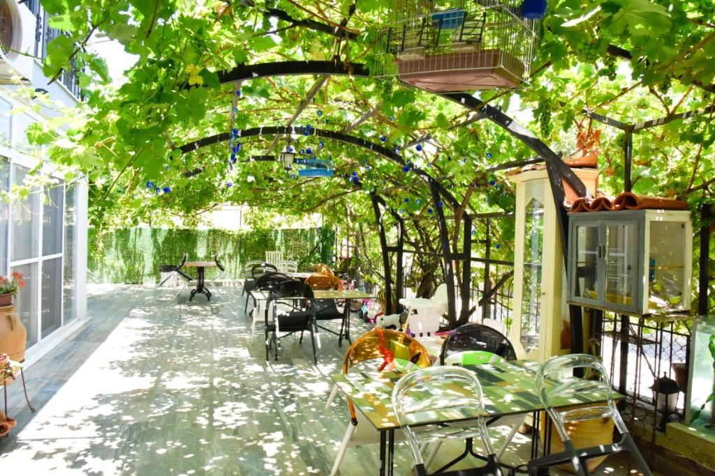 a greenhouse with tables and chairs under a tree at Balim Sultany in Çeşme