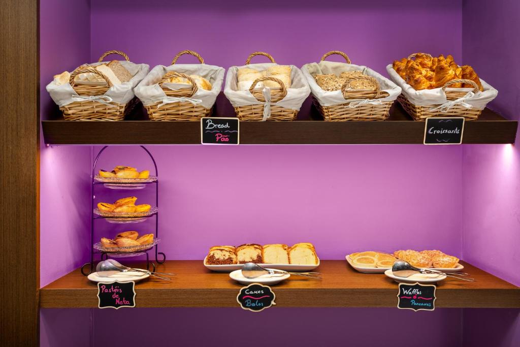 A bread and pastry station with labeled baskets and shelves.