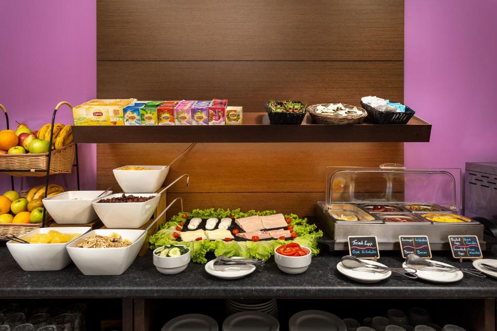 A refrigerated and prepared-food breakfast buffet with fruit, cereals and labeled dishes.