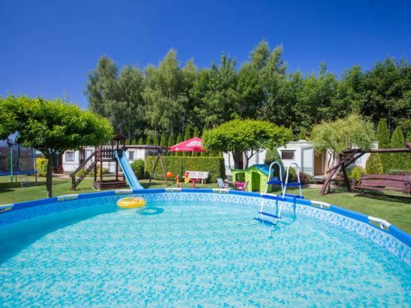 a large swimming pool with a slide and a playground at Domki u Ewy in Wrzosowo