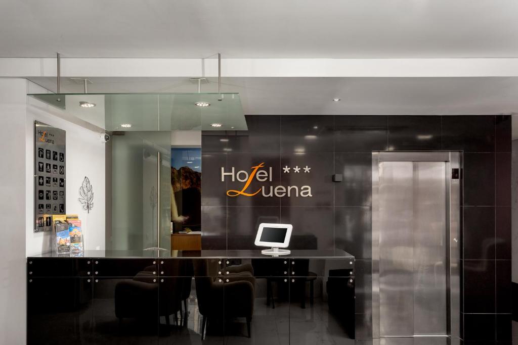 A small reception workspace includes a computer terminal, meeting table and elevator.