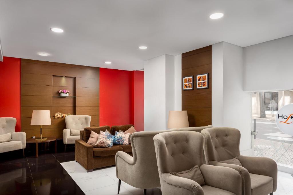 A formal lounge is furnished with armchairs, a sofa and lamps beside the hotel entrance.