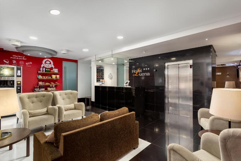 A bright hotel reception lounge with upholstered seating, a lift and front desk.