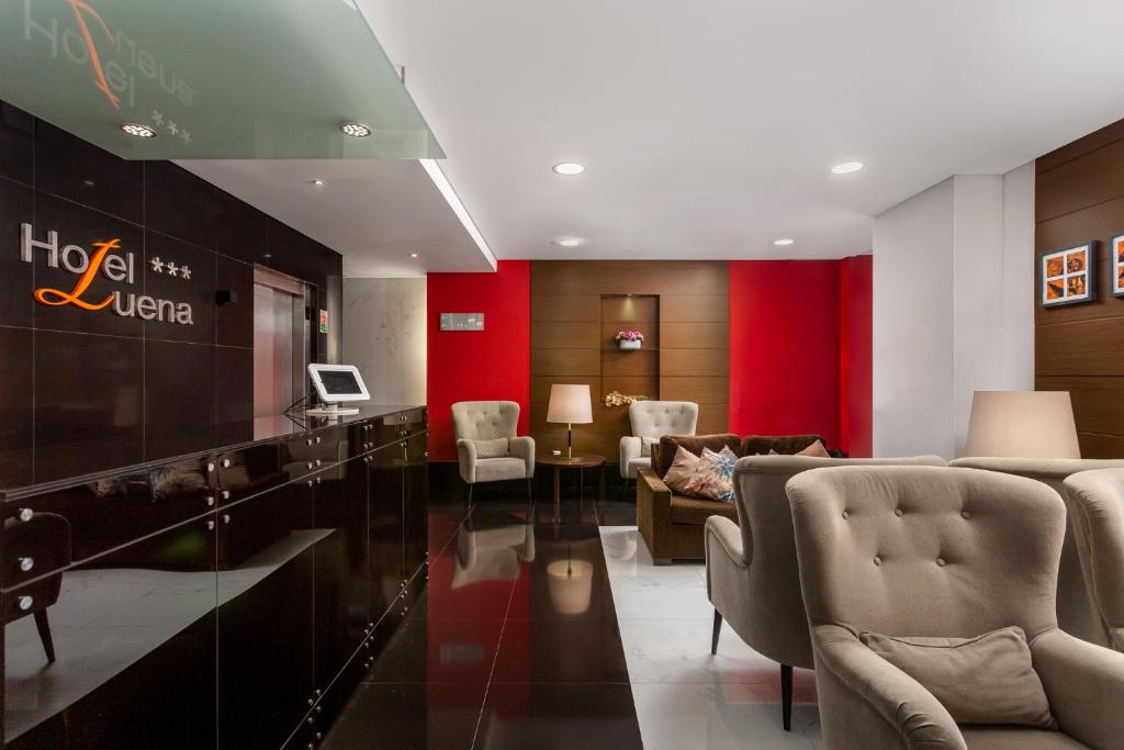 The polished lobby has upholstered seating, a reception desk and a television.