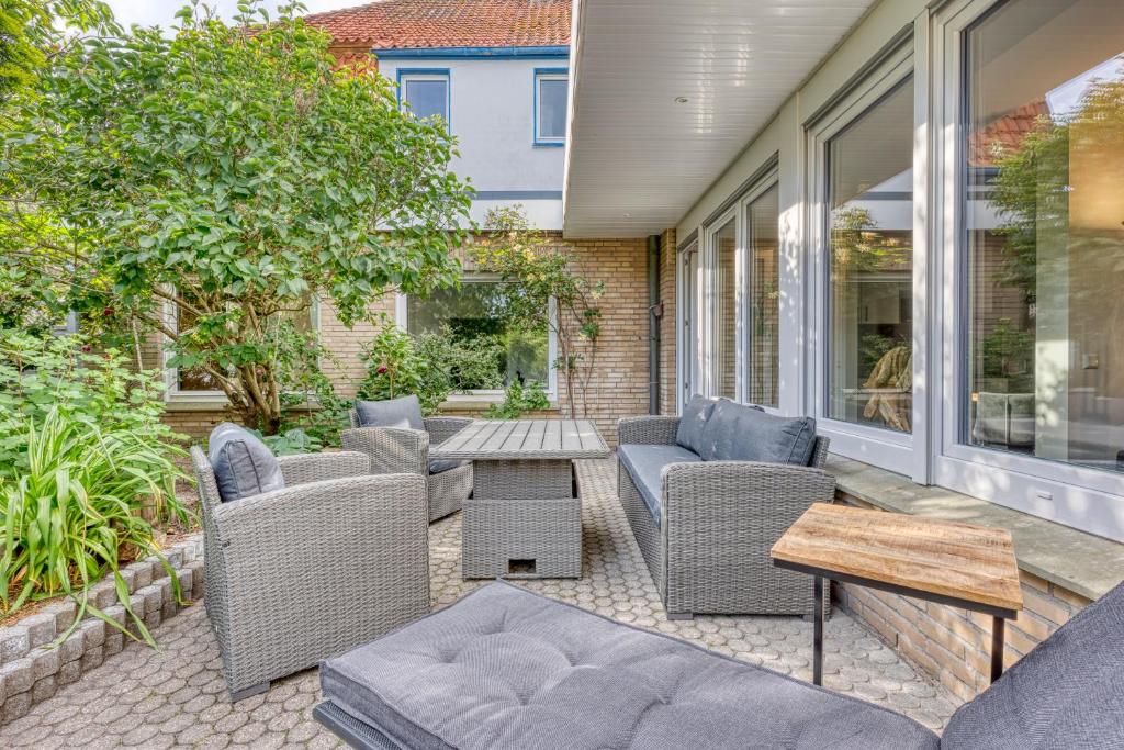 eine Terrasse mit Korbstühlen und einem Tisch in der Unterkunft Haus Kleemann E24 in Norderney