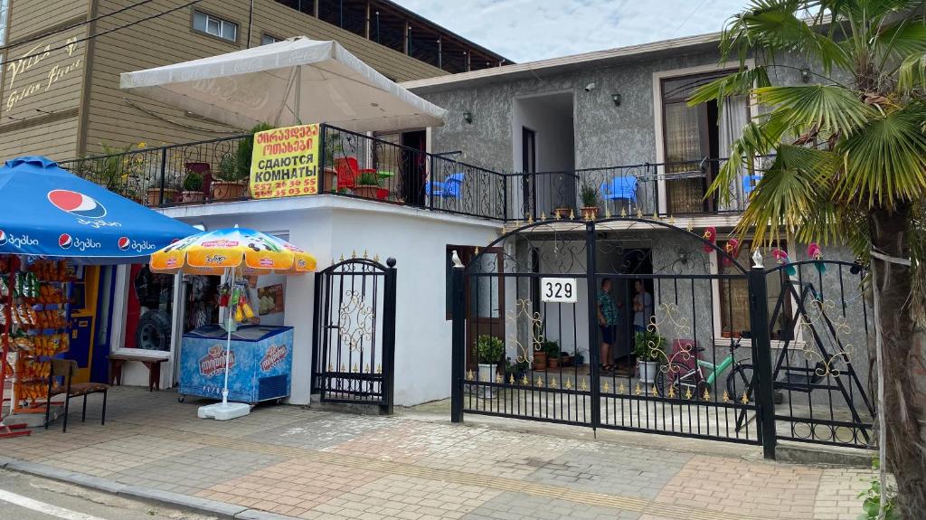 ein Gebäude mit einem Regenschirm und einem Laden in der Unterkunft Diana Guest house in Kobuleti